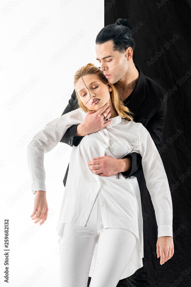 Model with hair bun holding tender young woman in hands Model with hair bun holding tender young woman in hands