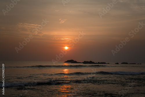 Beautiful orange sun at sunset and a path of light on the waters of the Indian Ocean