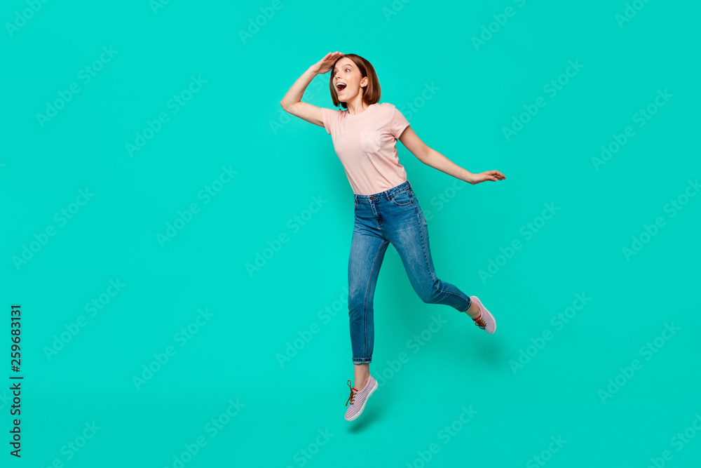 Full length body size photo beautiful her she lady jumping high hand arm forehead look search friend come meeting excited wear casual jeans denim pastel t-shirt isolated teal turquoise background