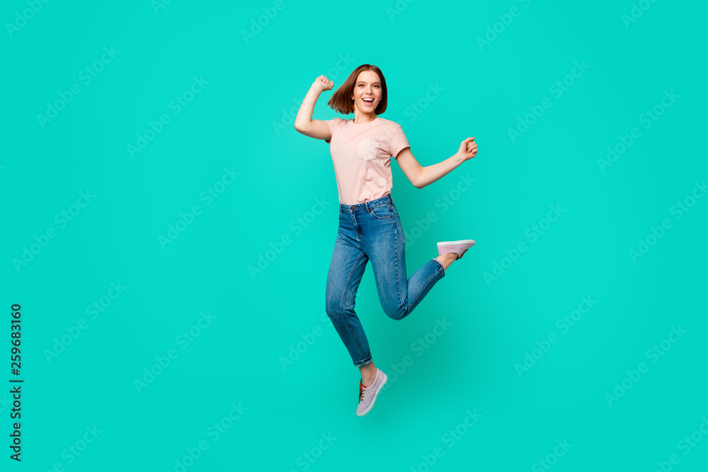 Full length body size photo beautiful amazing her she lady jumping high yell scream shout unexpected success short hairdo wear casual jeans denim pastel t-shirt isolated teal turquoise background Full length body size photo beautiful amazing her she lady jumping high yell scream shout unexpected success short hairdo wear casual jeans denim pastel t-shirt isolated teal turquoise background