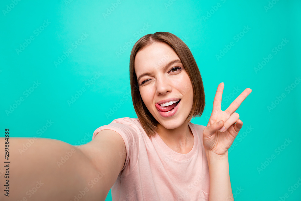 Close up photo beautiful her she lady tongue out mouth show v-sign say hi short straight hair make take selfies instagram post followers likes wear casual t-shirt isolated teal turquoise background Close up photo beautiful her she lady tongue out mouth show v-sign say hi short straight hair make take selfies instagram post followers likes wear casual t-shirt isolated teal turquoise background