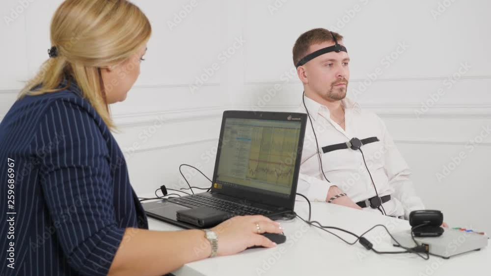Guy making a polygraph test. Businessman connected to the lie detector ...