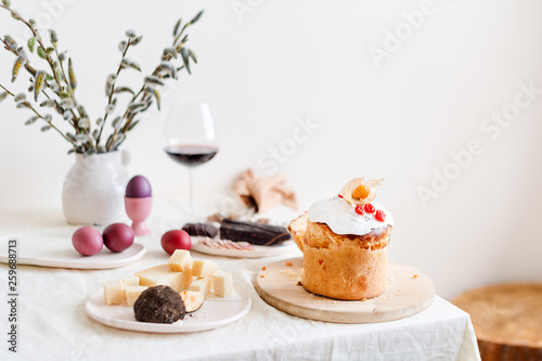 Easter cake and painted eggs. Easter composition with orthodox sweet bread, kulich and eggs on light background. Easter holidays breakfast