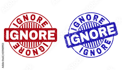 Grunge IGNORE round stamp seals isolated on a white background. Round seals with grunge texture in red and blue colors. Vector rubber imitation of IGNORE label inside circle form with stripes.