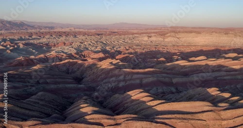 Flying over the red, colorful, rainbow mountains, covered with unique patterns, Iran. Aerial photography.