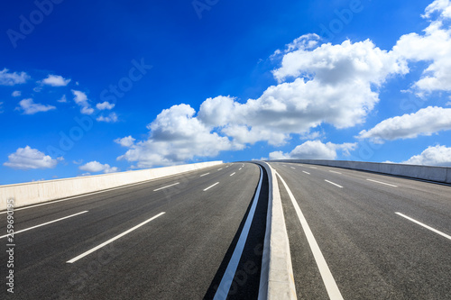 Empty asphalt road and blue sky with white clouds scene © ABCDstock