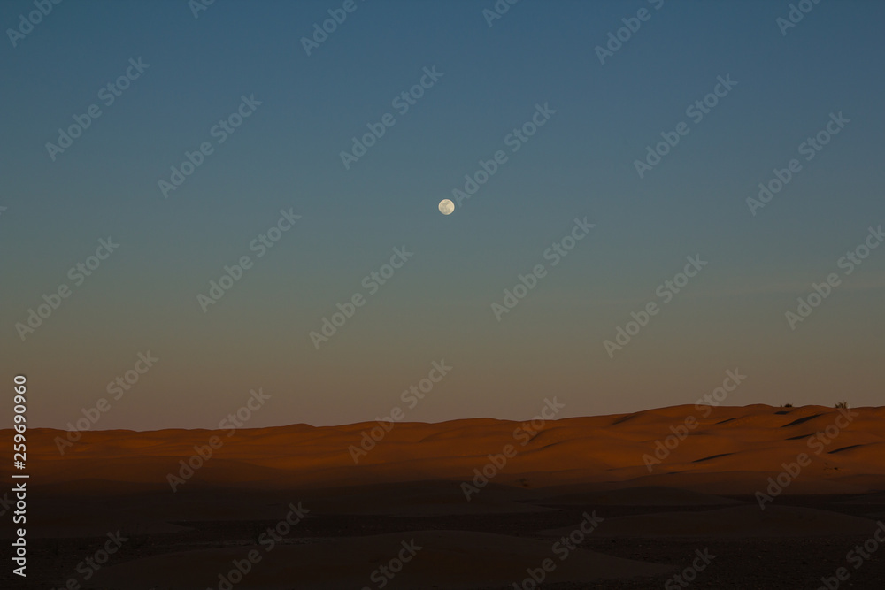 Full moon over the sand dunes during an off road trip through the northern Sahara in Tunisia  south of the city of Dousz