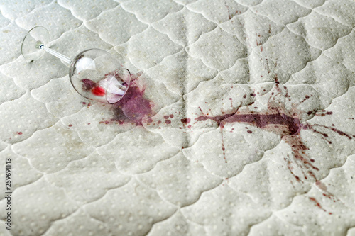 Valokuva Spilled wine glass on the bed
