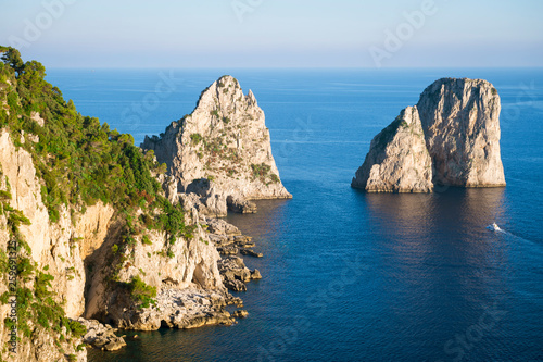 Bright scenic view of the iconic Faraglioni rocks from the nearby cliffside trail on the Mediterranean island of Capri, Italy © lazyllama
