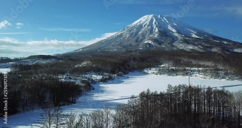 Aerial view of a large mountain in a snow covered landscape