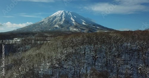 Aerial view of a large mountain in a snow covered landscape
