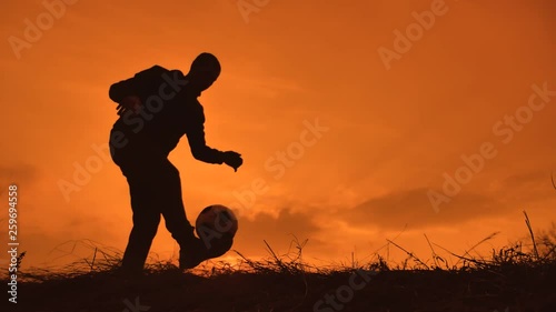 man is training freestyle bal Hacky On Sunset Sack silhouette freestyle concept lifestyle . man playing soccer stuffing a ball. sport and leisure concept photo