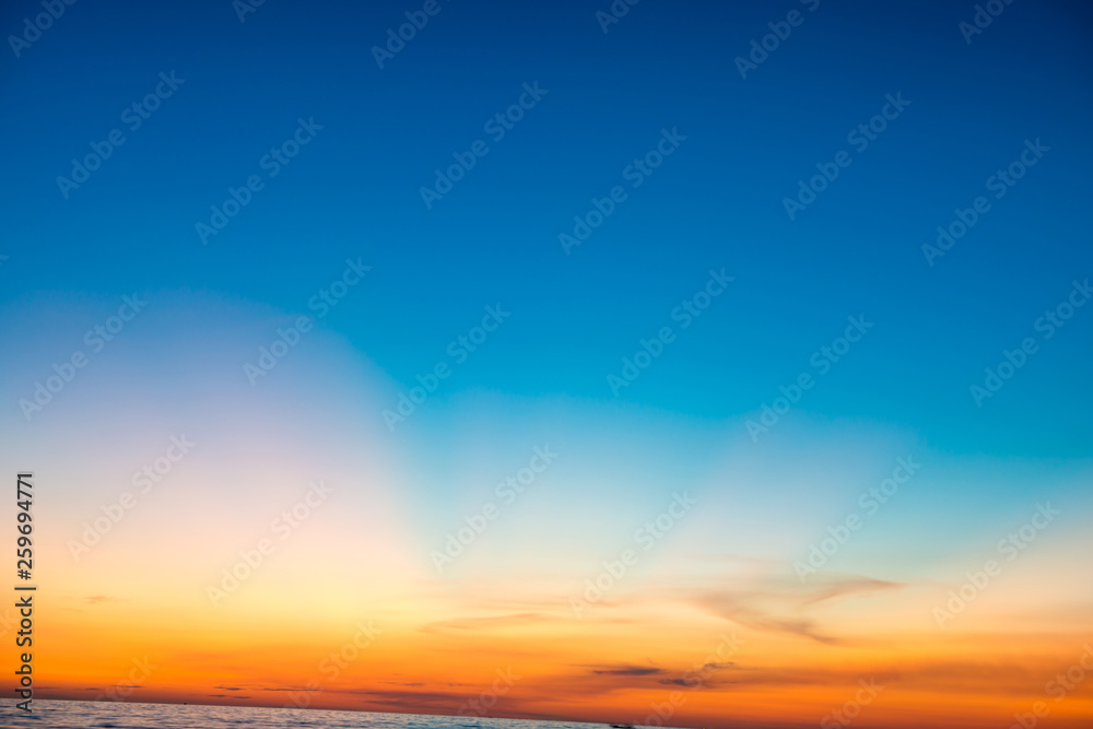 Blue dramatic sunset sky with golden rays of sun light. Can be used as nature background