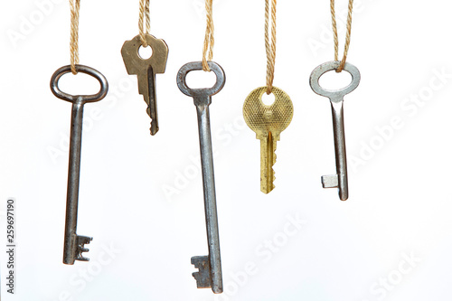 Keys are hanging on the clothesline on a white isolated background. Old keys. Conceptual