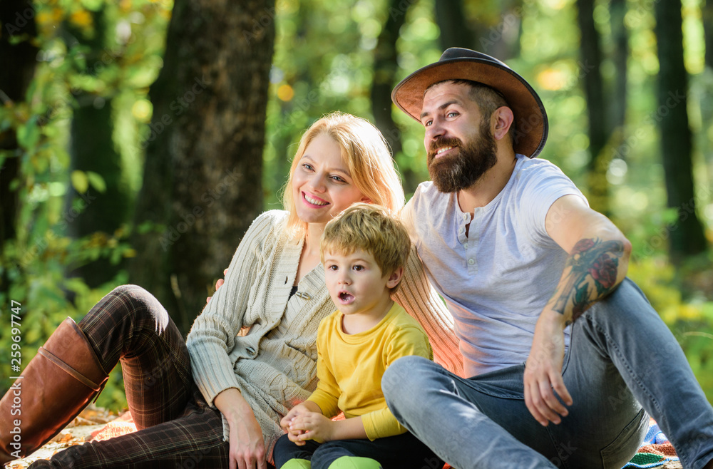 Happy son with parents relax in autumn forest. Sunny weather. Healthy food. Mother, cowboy father love their little boy child. Spring mood. Happy family day. Family picnic. Express positivity