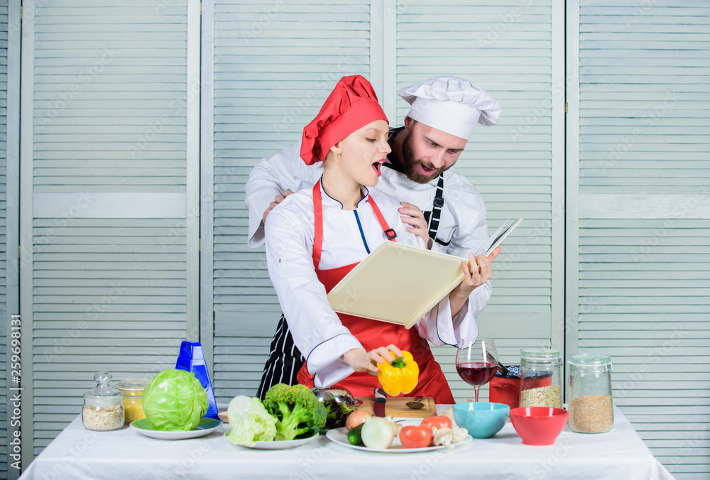 Amateur cook read book recipes. Improve cooking skill. Book recipes. Helpful culinary book. Woman chef and man cooking food together. Culinary family concept. Couple in love cooking healthy recipe Amateur cook read book recipes. Improve cooking skill. Book recipes. Helpful culinary book. Woman chef and man cooking food together. Culinary family concept. Couple in love cooking healthy recipe