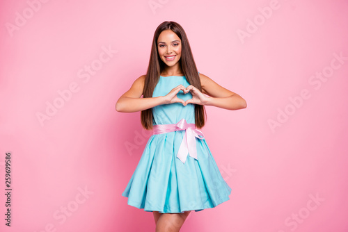Portrait of lovely model cute teenager teen showing affection attracting boys males men making heart with fingers isolated dressed in bright clothing on rose-colored background