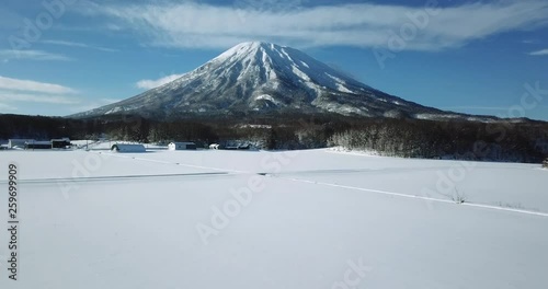 Aerial view of a large mountain in a snow covered landscape
