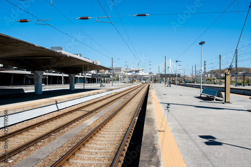 Beautiful railway station with modern commuter train at sunny day. Railroad outdoor platform