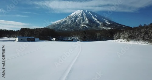 Aerial view of a large mountain in a snow covered landscape