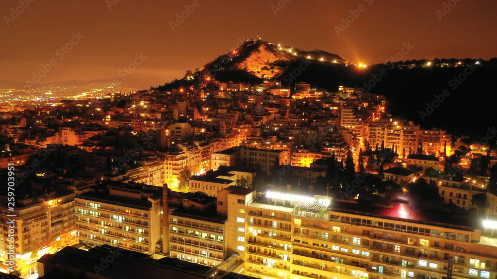 Aerial drone night shot of iconic Lycabettus hill and city of Athens illuminated, Attica, Greece