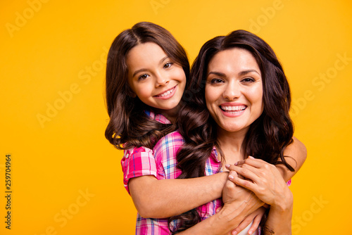 Close up photo of attractive cute lovely mature mum little kid show feelings trust warm comfort hugs satisfied candid rest isolated dressed checked trendy shirts touch hands yellow background