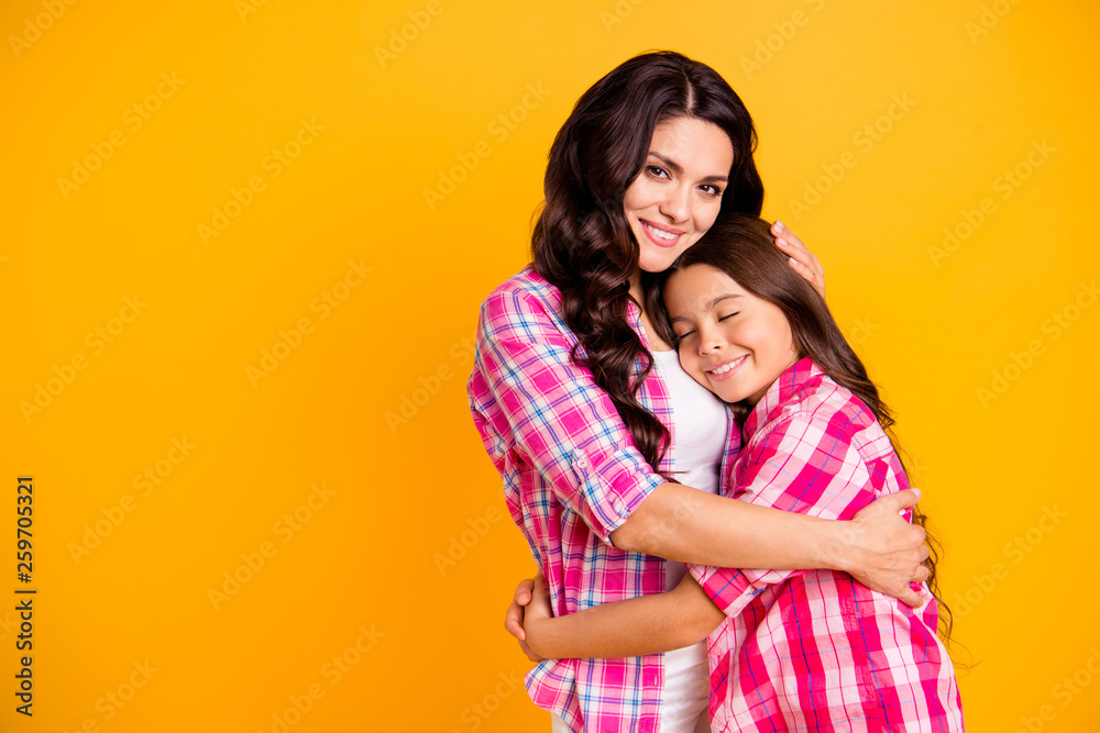 Close up photo two people funny brown haired she her ladies mum mommy treats small little daughter hold each other hands arms close wear casual pink checkered plaid shirts isolated yellow background
