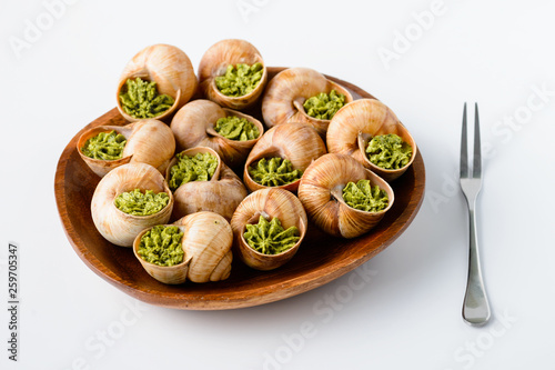 Large Escargots de Bourgogne Snails baked on light background. Healthy food concept with copy space.