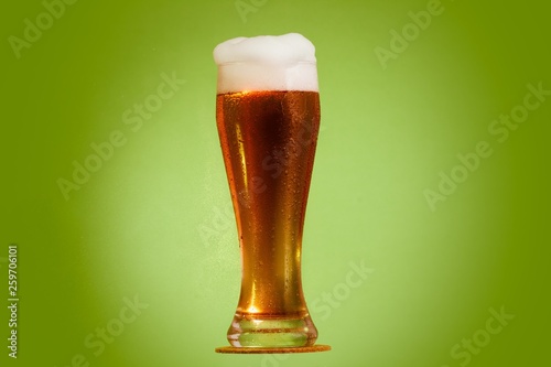 Golden beer in glass with foam, alcohol beverage, drop.