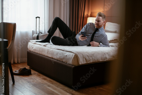 Businessman relaxing after meetings. Man checking his wifi connection at a hotel room.