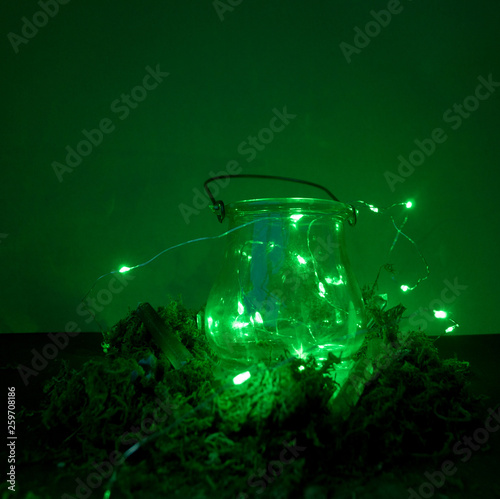 Magic cauldron on green background with moss and firefly and fog and smoke and bokeh