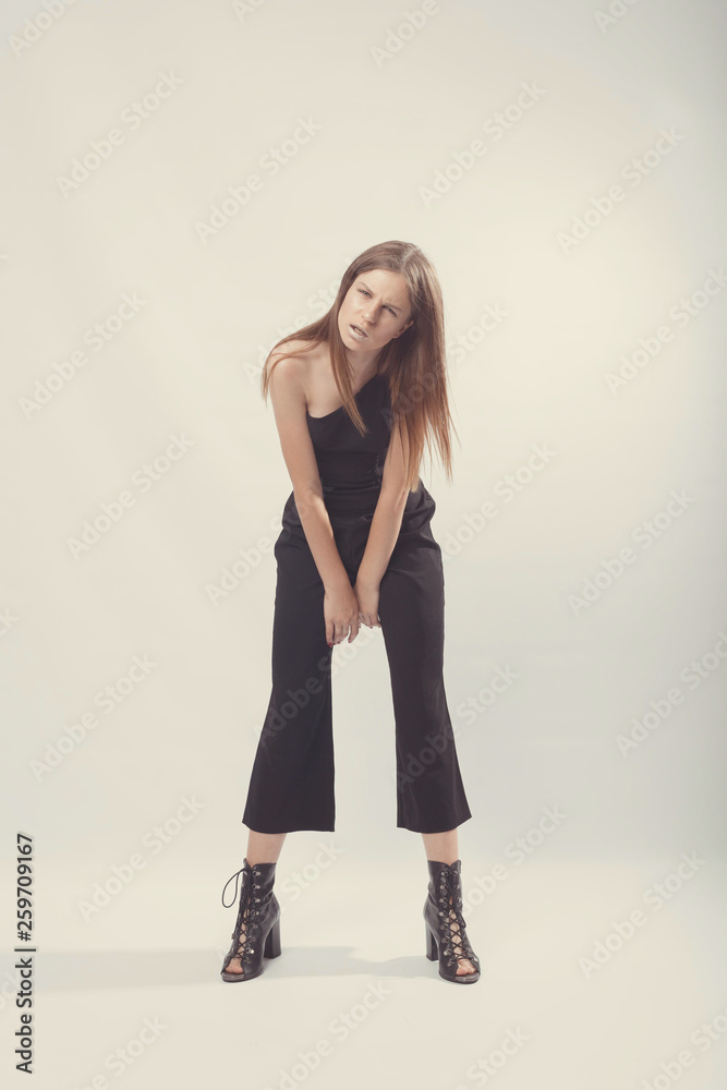 Fashionable girl in light tones in studio. Woman with unflappable face. Lifestyle concept in fashion world. Female in suit Fashionable girl in light tones in studio. Woman with unflappable face. Lifestyle concept in fashion world. Female in suit