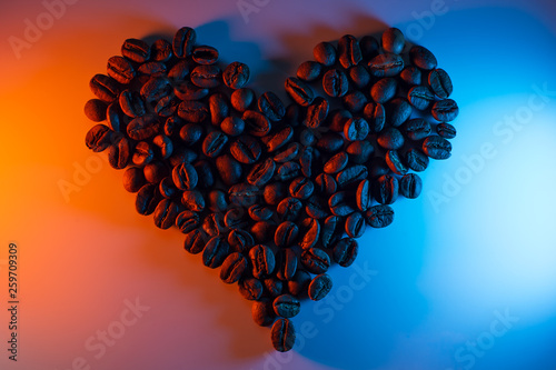 coffee beans are highlighted with neon lined in the shape of a heart photo