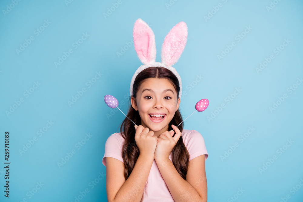 Close up photo portrait of surprised amazed shocked with beaming teeth smile in casual t-shirt cheerful ecstatic girl holding two bright vivid easter eggs in hands isolated pastel background