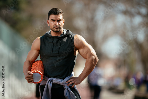 Athlete holding a foam roller, getting ready for a workout.