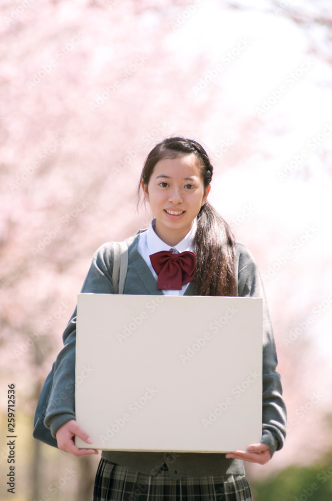 桜の前でメッセージボードを持つ中学生 桜の前でメッセージボードを持つ中学生