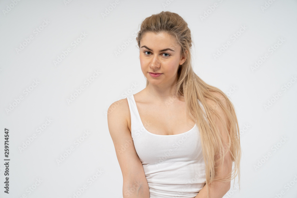 A young attractive girl in a white T-shirt looks into the camera. Isolated on white background A young attractive girl in a white T-shirt looks into the camera. Isolated on white background