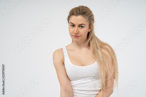 A young attractive girl in a white T-shirt looks into the camera. Isolated on white background