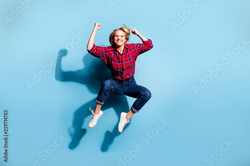 Full length body size view portrait of nice charming attractive cheerful cheery teen girl wearing checked shirt flying celebrate isolated on teal turquoise bright vivid shine background