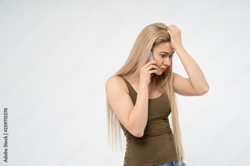 Young happy girl is surprised talking on the phone. Isolated on white background