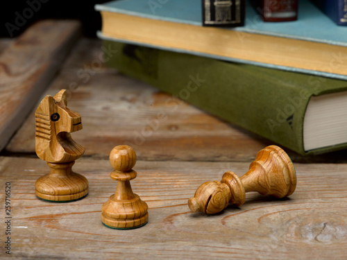 Bodegón figuras de ajedrez con libros y fondo de madera
