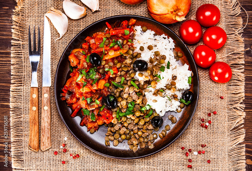 Rice with lentils and vegetables on wooden table