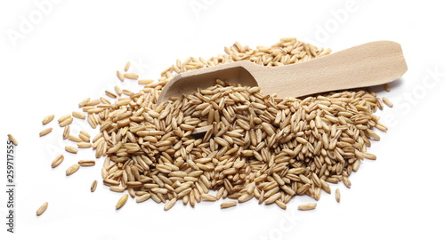 Peeled oat grains with wooden spoon isolated on white background