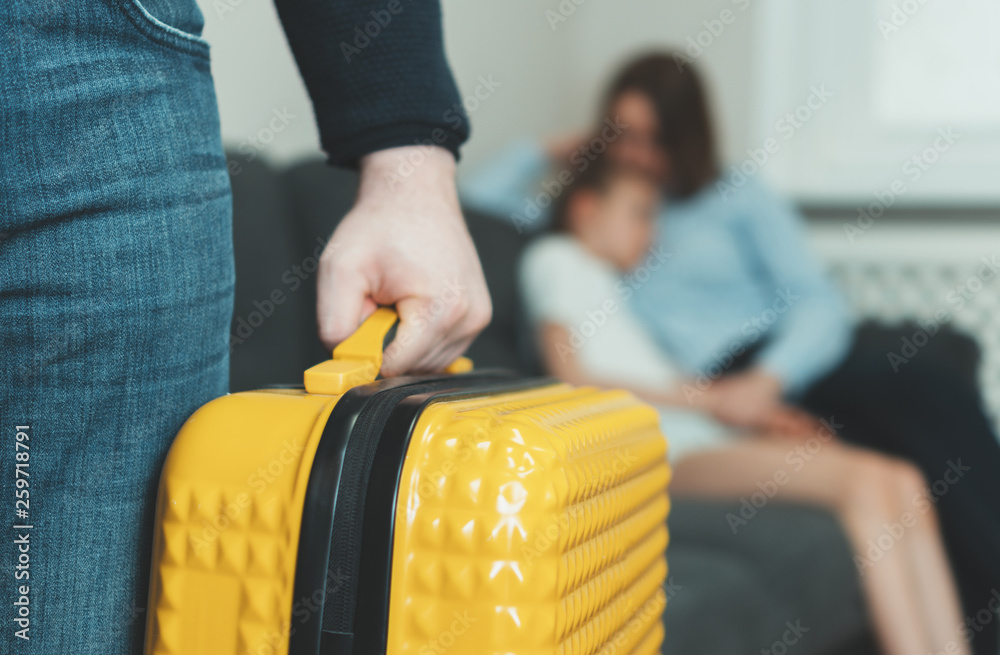 Fototapeta premium Domestic quarrel. Father with suitcase leaving his family.