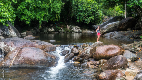 Young girl feeding fish by the river photo