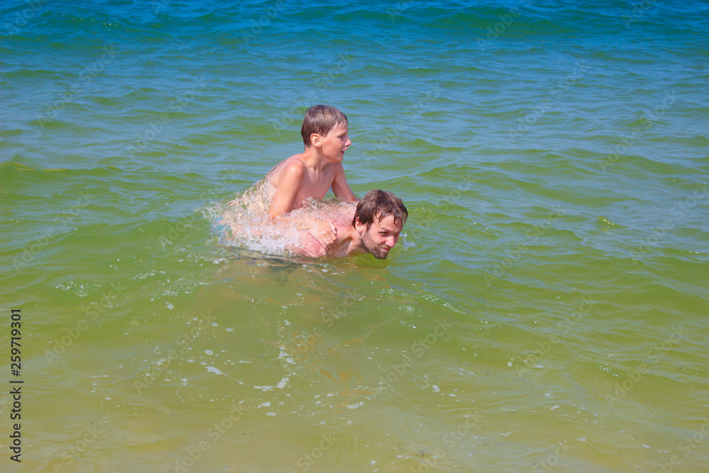 Father and son splashing in the sea