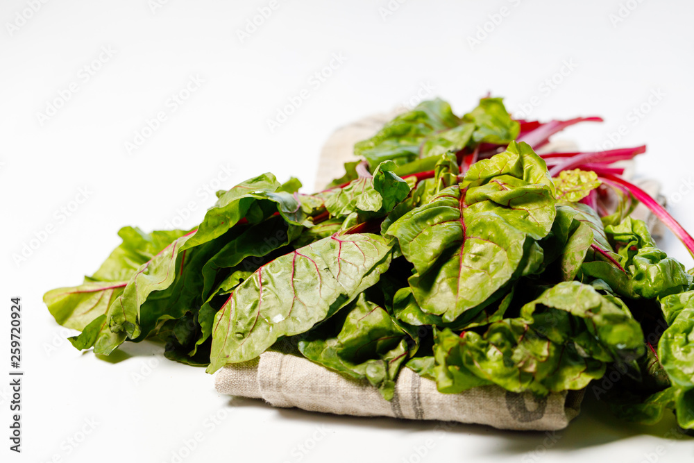 Beet leaves, fresh, juicy, green with red streaks, on a white background. Beet leaves, fresh, juicy, green with red streaks, on a white background.