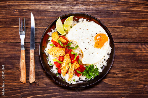 Grilled meat, white rice,fried egg vegetables on wooden table