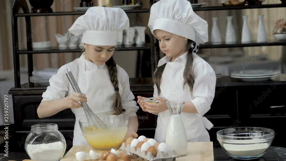 Funny young girls are preparing the dough in the kitchen Funny young girls are preparing the dough in the kitchen