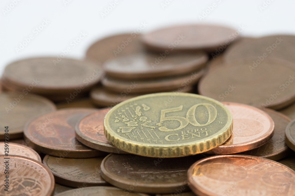 Coin of fifty euro cents on several bronze coins of five cents. White background Coin of fifty euro cents on several bronze coins of five cents. White background